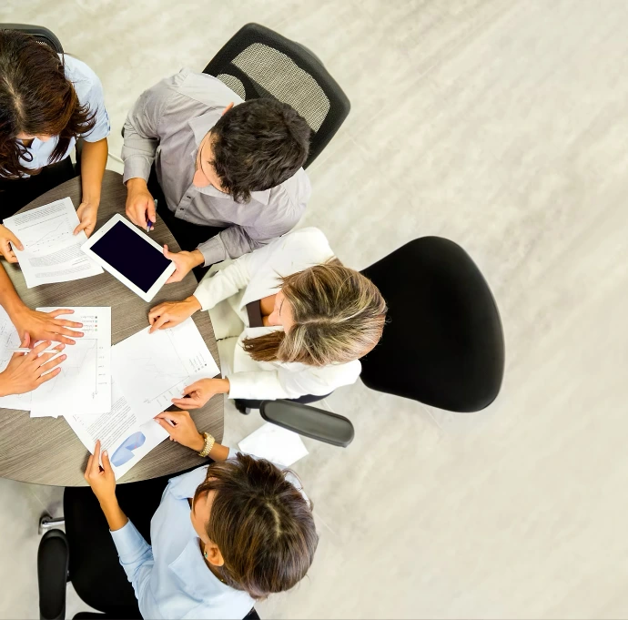 image showing an overhead view of four people sitting at a desk