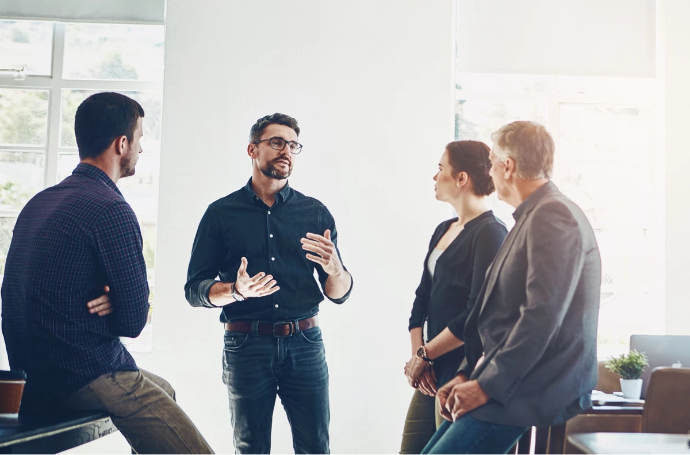 image of 4 people in a room listening to a mentor